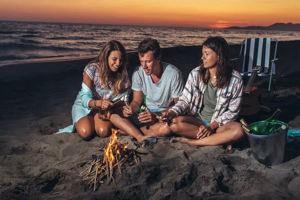 Grup Prieteni Care Relaxează Jurul Focului Tabără Plajă Apusul Soarelui — Fotografie, imagine de stoc