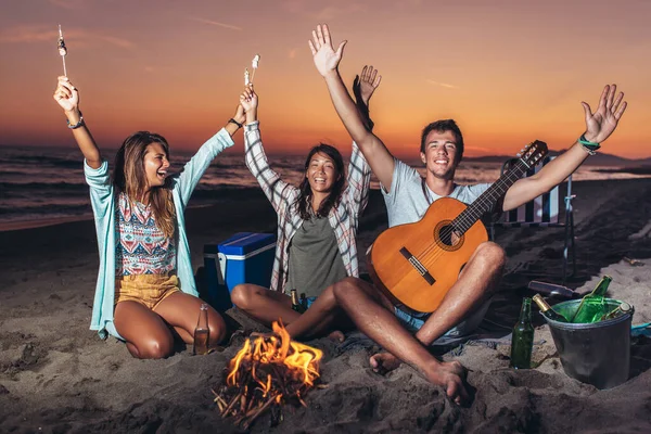 Vriendengroep Ontspannen Rond Vreugdevuur Het Strand Bij Zonsondergang — Stockfoto