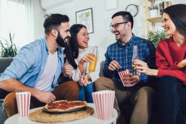 Evde pizza yiyen bir grup genç arkadaş. Gençler birlikte eğleniyor.. 