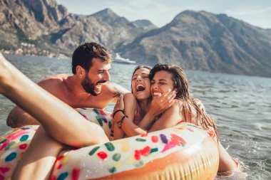 Genç trend insanlar yaz tatilinde yüzerek eğleniyorlar, şişme yüzükle rahatlıyorlar..