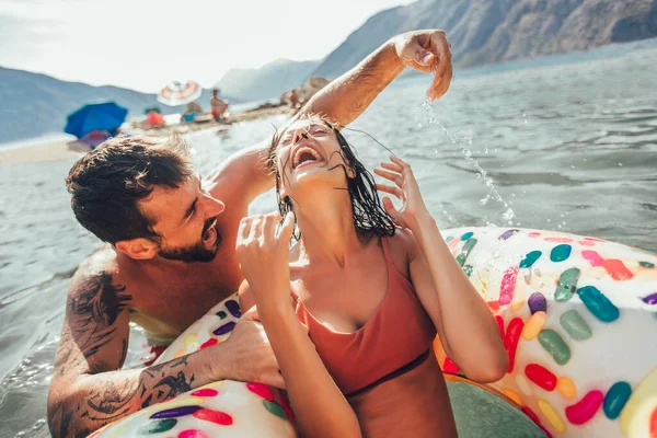 年轻貌美的情侣们在暑假游得很开心 在充气环上放松一下 — 图库照片