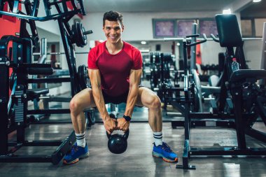 Spor salonunda egzersiz yapan yakışıklı bir genç.