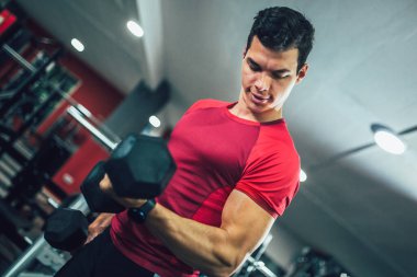 Spor salonunda egzersiz yapan yakışıklı bir genç.