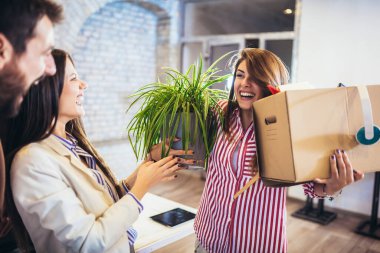 Kadının ilk iş günü modern ofise giriyor, kişisel eşyalarıyla uğraşıyor..