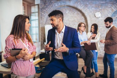 Modern ofiste yeni bir proje üzerinde çalışan iki tasarımcı.