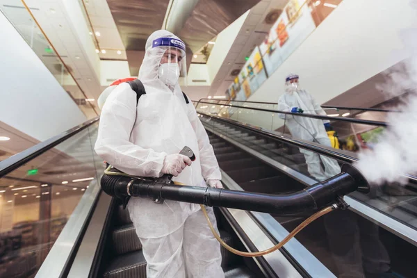 ハズマットスーツの専門労働者は モール パンデミック健康リスク コロナウイルスの屋内を消毒する — ストック写真