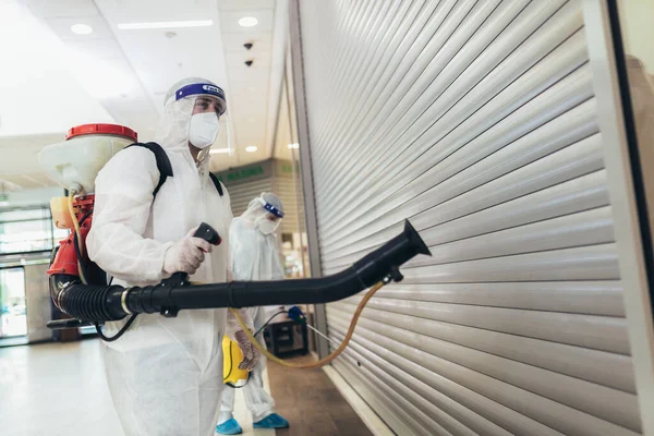 Trabajadores Profesionales Trajes Materiales Peligrosos Desinfectando Interiores Centros Comerciales Riesgo — Foto de Stock