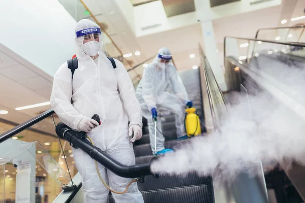 Professionele Werknemers Hazmat Pakken Desinfecteren Binnenshuis Van Winkelcentrum Pandemische Gezondheidsrisico — Stockfoto