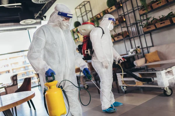 Pekerja Profesional Dalam Pakaian Hazmat Mendisinfeksi Dalam Ruangan Kafe Atau — Stok Foto