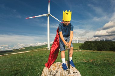 Küçük çocuk oyuncak kılıcı tut Rüzgâr çiftliğinin önünde oynuyor