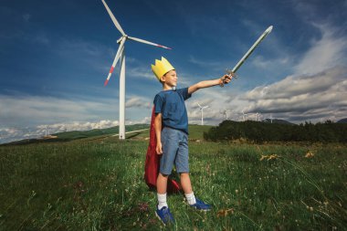 Küçük çocuk oyuncak kılıcı tut Rüzgâr çiftliğinin önünde oynuyor