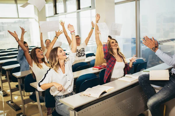 Group of students raising hands in class on lecture