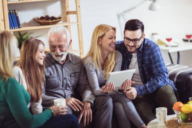 Dijital tablet kullanarak evde birlikte vakit üç nesil aile portresi.