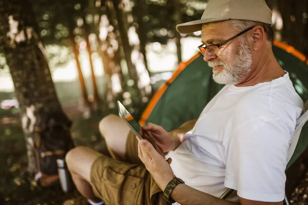 Man Kamperen Natuur Kijken Naar Digitale Tablet Glimlachen — Stockfoto