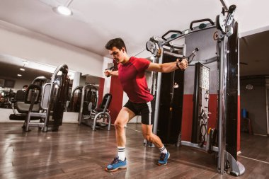 Spor salonunda egzersiz yapan yakışıklı bir genç.