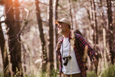 Yetişkin bir adam ormanda yürüyüş yapıyor.
