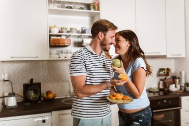 Hamile kadın ve kocası mutfakta.