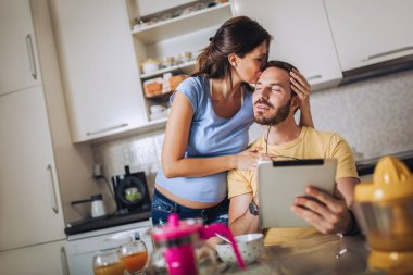 Hamile kadın ve kocası mutfakta.