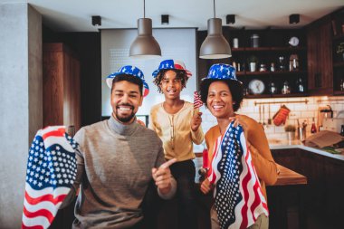 Aile, 4 Temmuz 'da oturma odasında bayraklarla gülümsüyor.