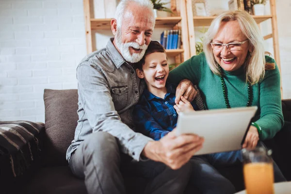 Young boy showing his older grandparents new technology