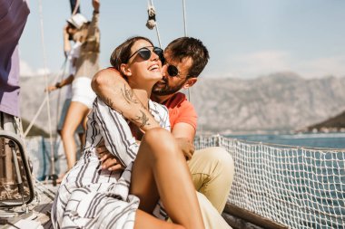 Sevgi dolu çift denizde yatta mutlu vakit geçiriyor. Deniz kenarında lüks bir tatil.. 