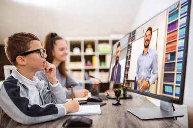 Oğlan ve kız evde çalışıyor ve okul ödevi yapıyor. Uzaklık öğrenimi çevrimiçi eğitim.