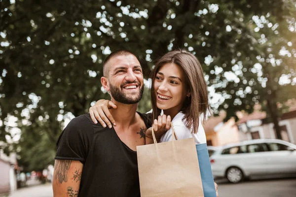 街で買い物をした後のショッピングバッグと幸せなカップルの肖像笑顔と抱擁 — ストック写真