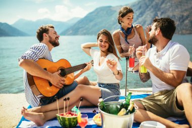 Gitarlı bir grup arkadaş sahilde eğleniyor..