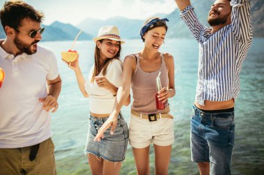 Plajda kokteyl içen arkadaşlar yaz tatilinde eğleniyorlar.
