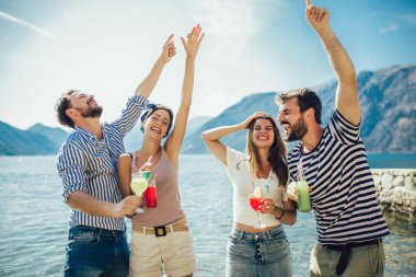 Plajda kokteyl içen arkadaşlar yaz tatilinde eğleniyorlar.