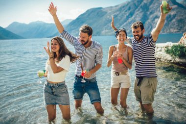 Plajda kokteyl içen arkadaşlar yaz tatilinde eğleniyorlar.