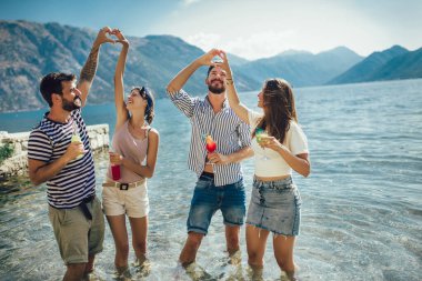 Plajda kokteyl içen arkadaşlar yaz tatilinde eğleniyorlar.