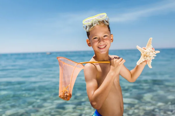 小男孩在海底与海星玩耍 — 图库照片