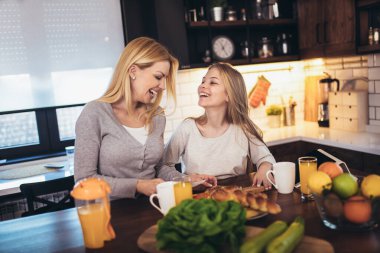 Mutlu anne ve kız kahvaltı hazırlıyor ve birlikte vakit geçiriyorlar.