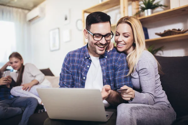 Unga Föräldrar Koppla Hemma Soffan Med Hjälp Laptop För Online — Stockfoto