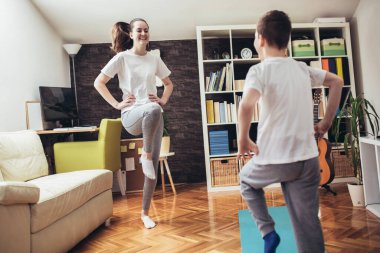 Çocuklar evde egzersiz yapıyor. Aile evde çalışıyor..