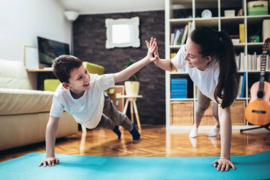 Çocuklar evde egzersiz yapıyor. Aile evde çalışıyor..