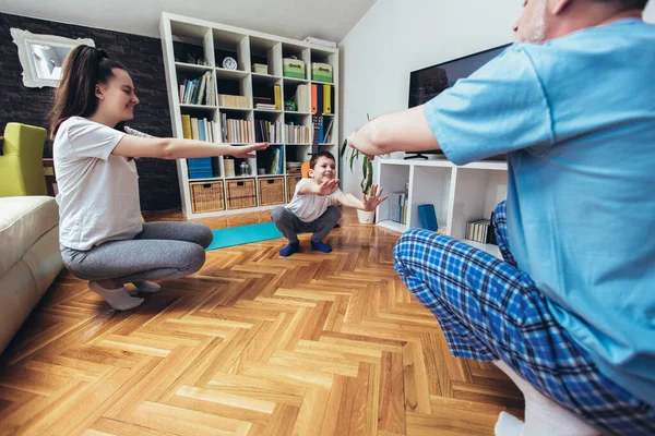 Healthy morning stretching - man with kids doing gymnastic exercise at home