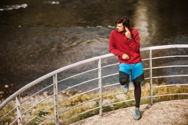 Adam dinleniyor ve biraz serinliyor. Genç erkek sporcu koşuya ara veriyor..