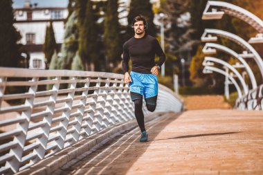 Modern köprü boyunca koşan çekici fit adam. Egzersiz, koşu, spor. Erkek sporcu.