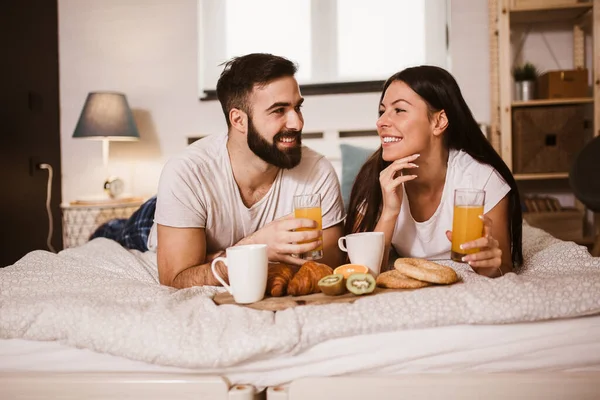 一对可爱的夫妇在卧室的床上吃早餐 — 图库照片