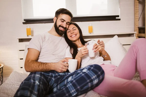 年轻快乐的夫妻早上在床上喝咖啡 — 图库照片