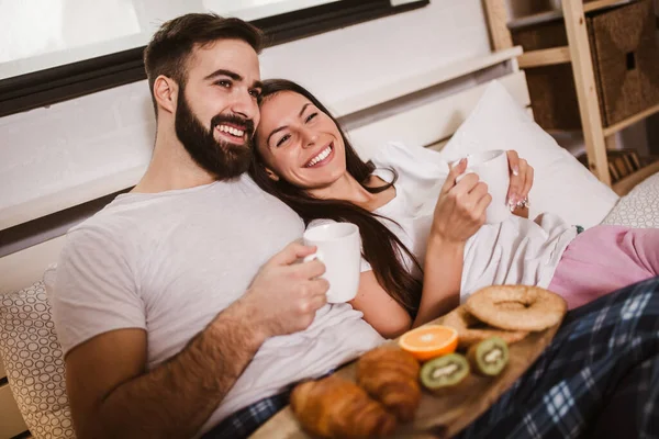 年轻快乐的夫妻早上在床上喝咖啡 — 图库照片
