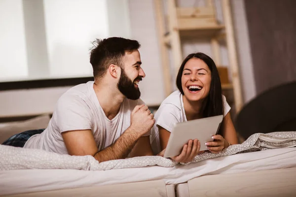 Sonriente Pareja Joven Relajada Usando Tableta Digital Cama Casa — Foto de Stock