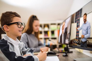 Oğlan ve kız evde çalışıyor ve okul ödevi yapıyor. Uzaklık öğrenimi çevrimiçi eğitim.