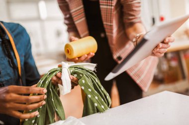 Stüdyoda çalışan terzi kadın dijital tablet kullanıyor..