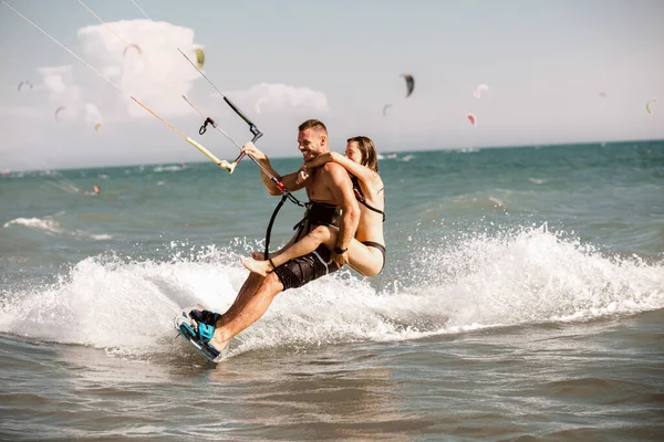 Kitesurfing Mężczyzna Jeździ Latawcu Falach Dziewczyną — Zdjęcie stockowe