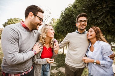 Bir grup genç parkta yürüyor. Arkadaşlar dışarıda eğleniyor.