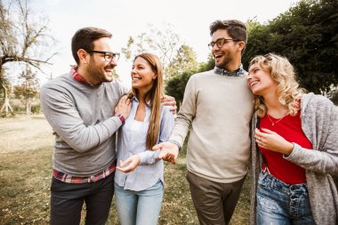 Bir grup genç parkta yürüyor. Arkadaşlar dışarıda eğleniyor.