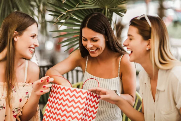 Bir kafede alışveriş yapan üç genç kadın.